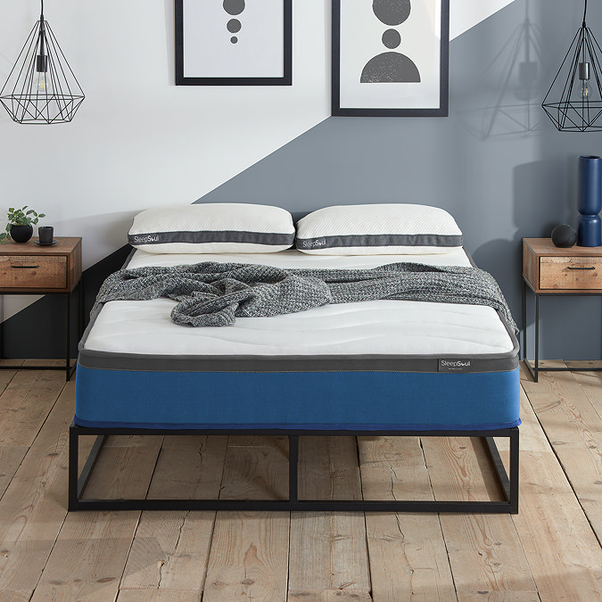 front-on image of double mattress with blue base, pushed against light blue wall