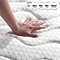 close up on hand touching top of mattress to feel texture and firmness