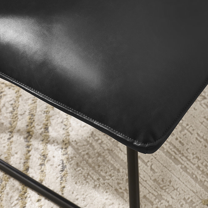 close up image of faux leather lounge chair with sleek black legs