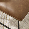 close up image of brown faux leather seat of brown lounge chair