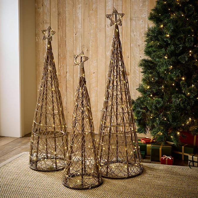 trio of wicker christmas trees, stood on rug in living room