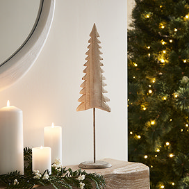 small whitewashed wooden tree decoration, stood at the end of a pale oak mantlepiece.