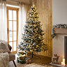 snowy pine tree with LEDs stood in warm living room