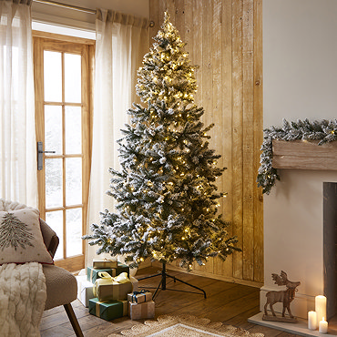 close up on snowy branches of artificial christmas tree with warm white LEDs