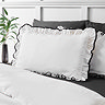 close up image of white pillowcase with black ruffle trim