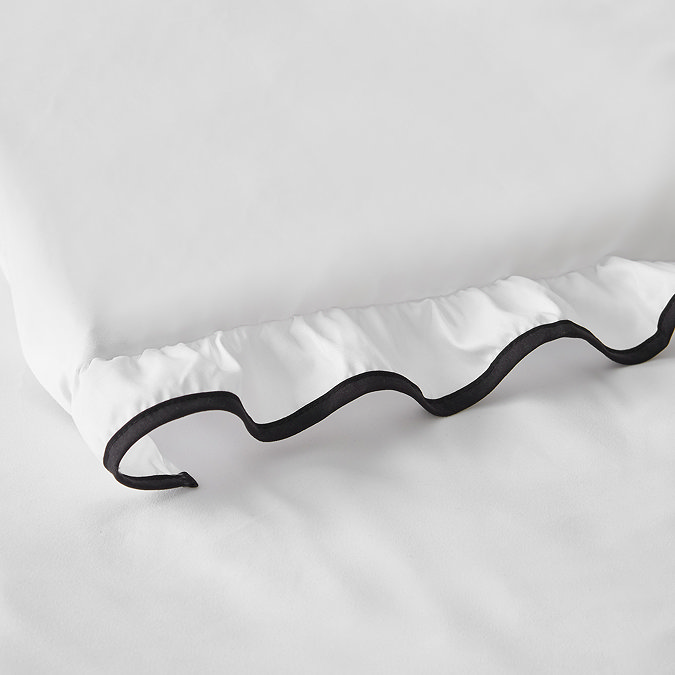 close up image on black frill edge of white bedding