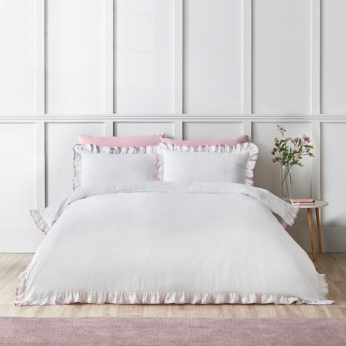 image of crisp white bedding with ruffle trim and pink contrast border