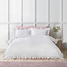 image of crisp white bedding with ruffle trim and pink contrast border