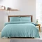 front image of duck egg blue duvet cover set on a bed with Nordic headboard