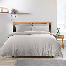 light grey duvet cover set on a bed with nordic headboard