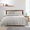 light grey duvet cover set on a bed with nordic headboard