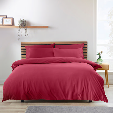 side-on image of hot pink duvet cover set on a bed, with matching fitted sheet and pillowcases