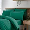 side-on image of teal green duvet cover set, slightly folded back to reveal matching fitted sheet and pillowcases