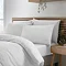 side-on image of soft white duvet cover set on a bed, slightly folded back at the top