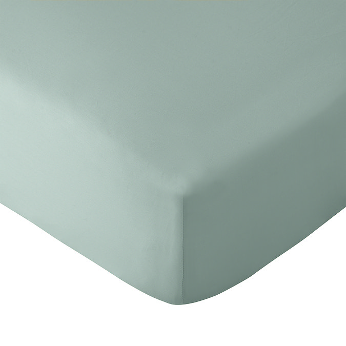 image cut out on white background of light green fitted sheet over corner of a mattress