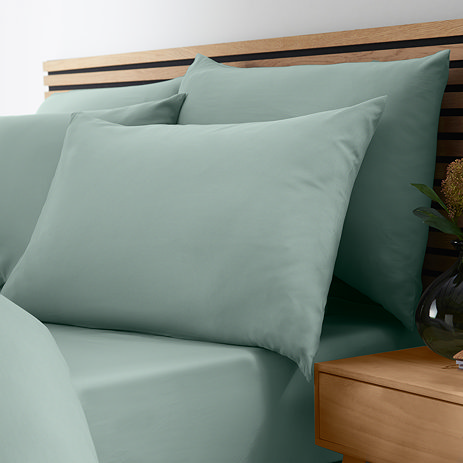 image of light green fitted sheet on bed with matching duvet and pillows