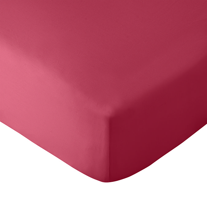 close up on corner of mattress covered with hot pink fitted sheet, image cut out on white background