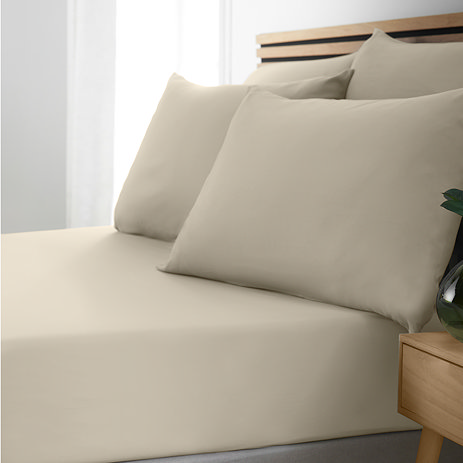 side-on image of bed with natural coloured fitted sheet and matching pillowcases