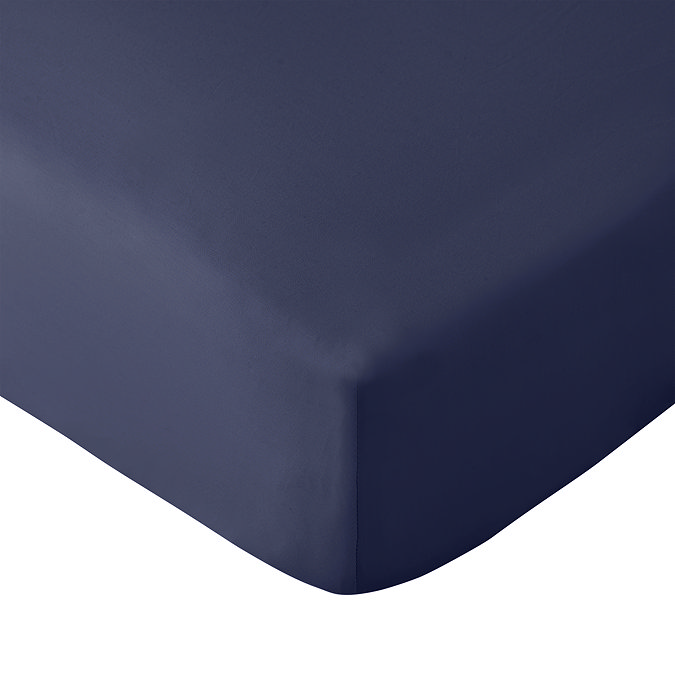 close up on corner of mattress with navy blue fitted sheet, image cut out on white background