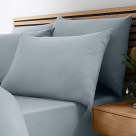 side-on image of bed with duvet cover folded over slightly to reveal slate grey-blue fitted sheet with matching pillowcase set