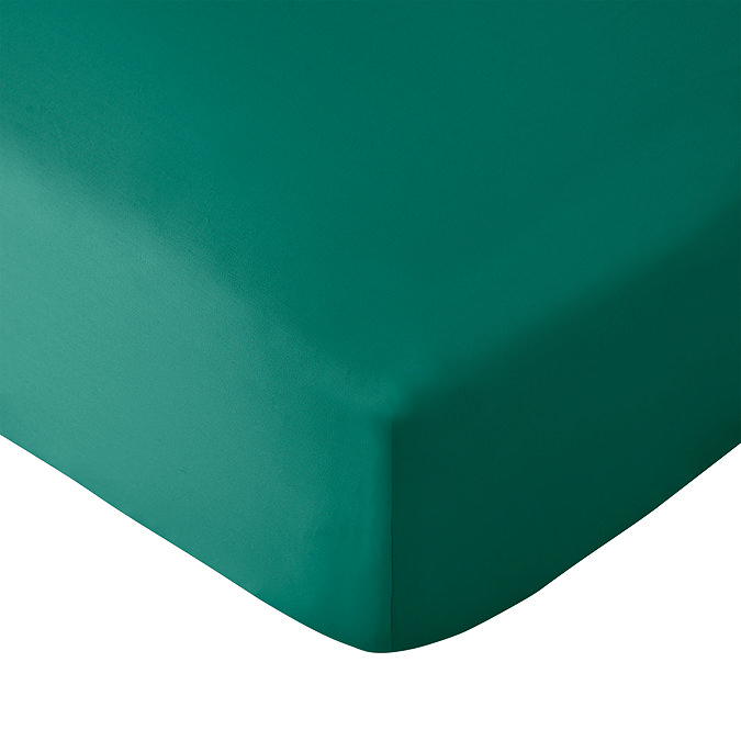 close up on corner of mattress covered with teal green fitted sheet, image cut out on white background