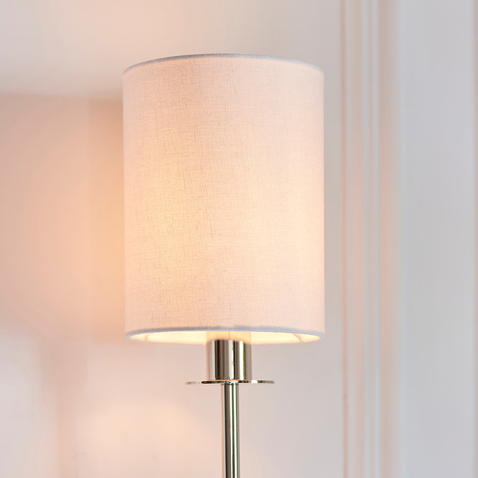 close up on cylindrical fabric shade of wall light