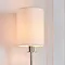 close up on cylindrical fabric shade of wall light