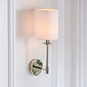 image of wall light with cylindrical fabric shade and nickel arm on cream wall