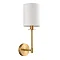 image cut out on white background of wall light with cylindrical white linen shade and satin brass arm