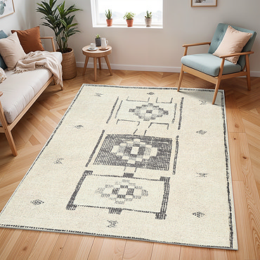close up image of ivory rug with black scandi geometric pattern, ruched up slightly to show its thinness