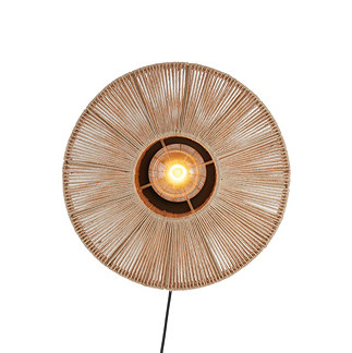 image cut out on white background of circular woven natural coloured lamp with central bulb emitting warm glow