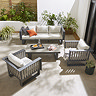 image taken from slightly above of modern slatted grey outdoor lounge set with cream cushions, on patio during a sunny day