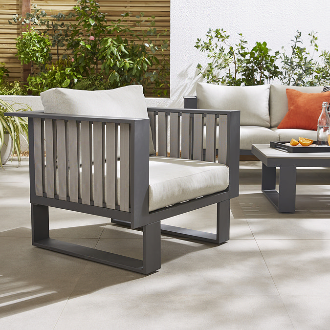 close up image of armchair part of outdoor lounge set, with grey slatted design