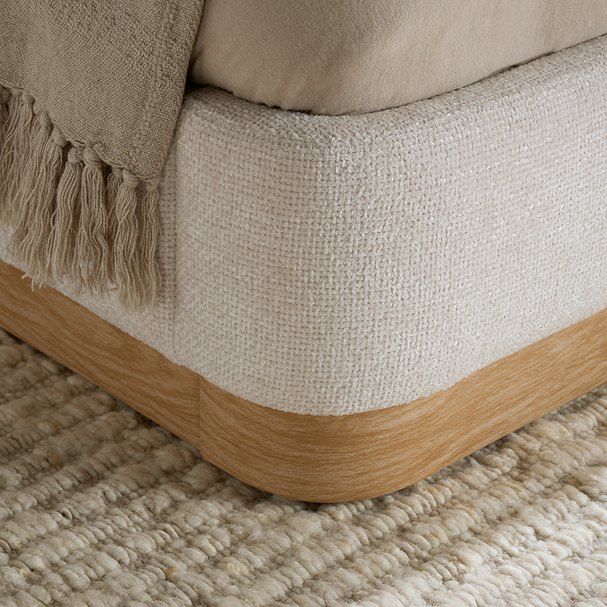 close up on bottom half of fabric bed with bottom wood effect panel