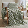 sage green cushion with coordinating throw on a chair