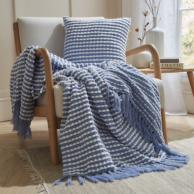 blue stab stitch throw with coordinating cushion on a chair