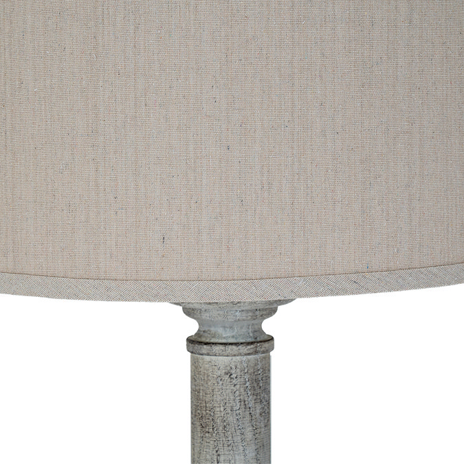 close up image of natural linen shade with grain, on top of white resin lamp