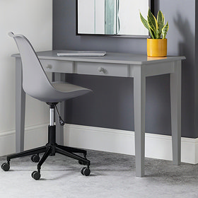 image of classic grey desk with two drawers pushed against grey wall, with matching grey chair pushed slightly underneath.