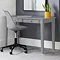 image of classic grey desk with two drawers pushed against grey wall, with matching grey chair pushed slightly underneath.