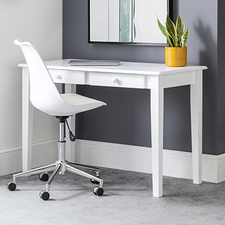 image of slim white desk with two thin drawers lengthways at the top, pushed against a grey wall with a plant on top and swivel chair pushed under