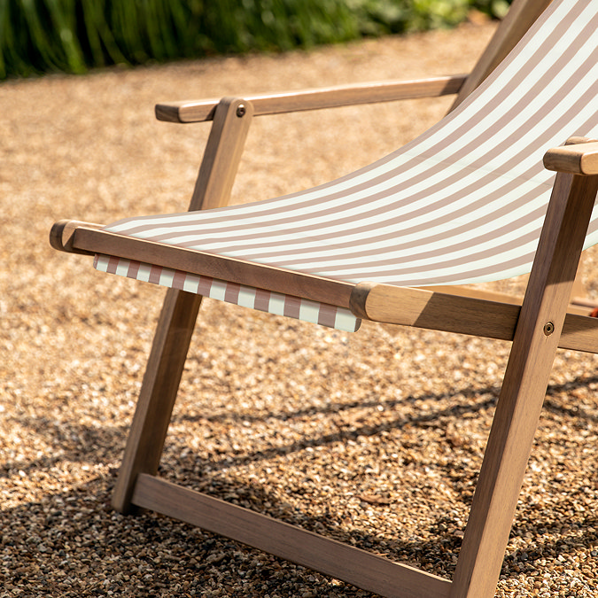 close up image of acacia wood frame of clay pink and white striped sun lounger