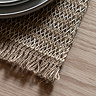 close up on fringed edge of woven striped jute placemat, highlighting the material and texture of the set
