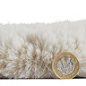 side-on image of faux sheepskin rug with pound coin stood up next to it to show rug as double the height of coin