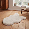 image of fluffy beige faux sheepskin rug on a wooden floor next to a widow with natural light streaming through