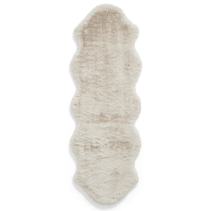 image cut out on white background of double length beige sheepskin rug with wavy sides and soft pile