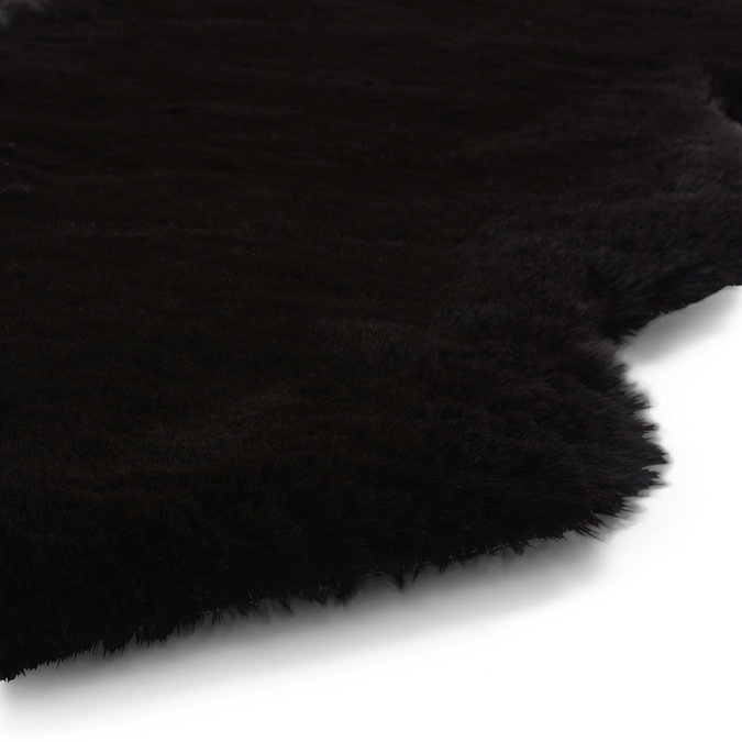close up image of wavy edges of black sheepskin rug