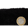 side-on image of faux sheepskin rug with pound coin stood up next to it to show rug as double the height of coin