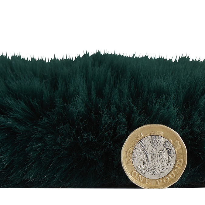 side-on image of faux sheepskin rug with pound coin stood up next to it to show rug as double the height of coin