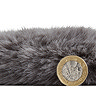 side-on image of faux sheepskin rug with pound coin stood up next to it to show rug as double the height of coin