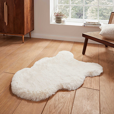 image of long ivory rug with wavy edges on wooden flooring in front of window with natural light streaming through